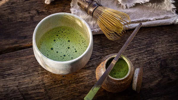 Preparing matcha tea with a bamboo whisk